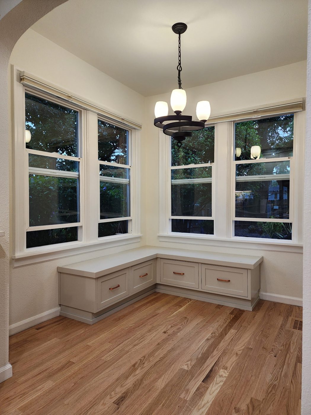 Built-in window seat with storage drawers in a bay window nook
