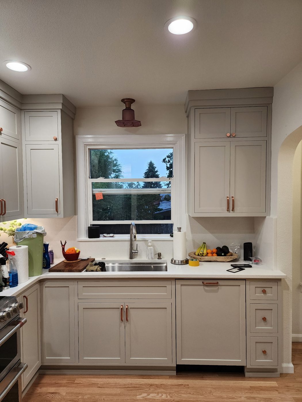 Greige kitchen cabinets with copper hardware
