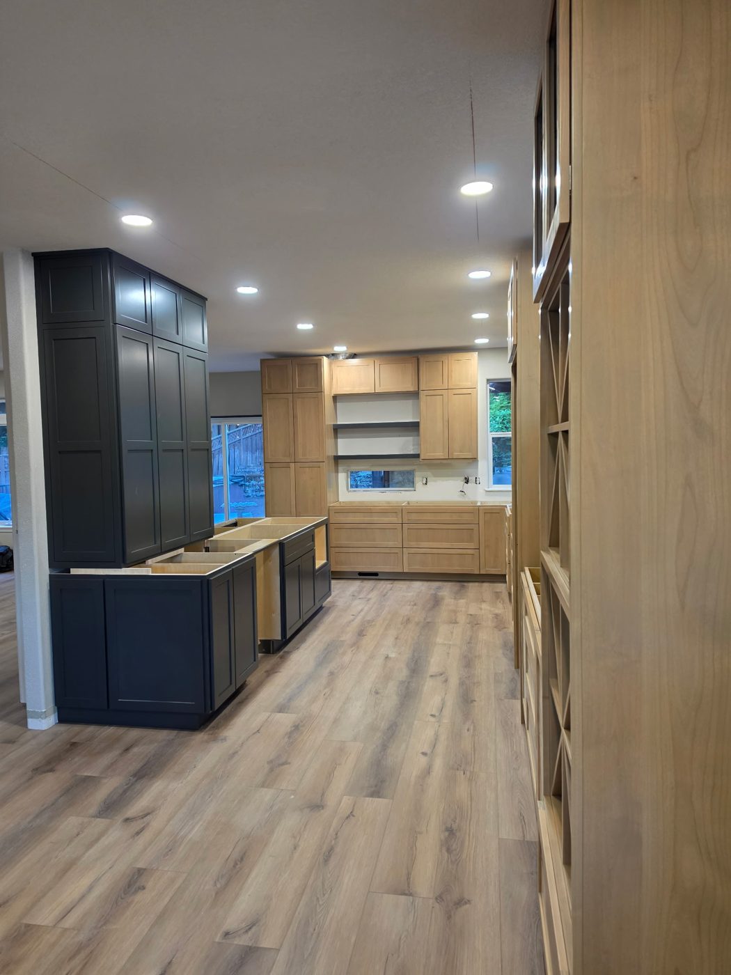 In-progress kitchen install with navy and natural wood cabinetry