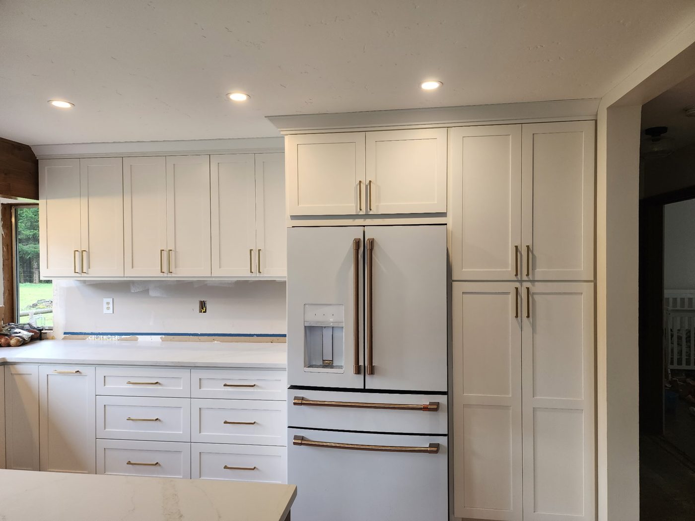 Finished white shaker kitchen cabinets with brass pulls