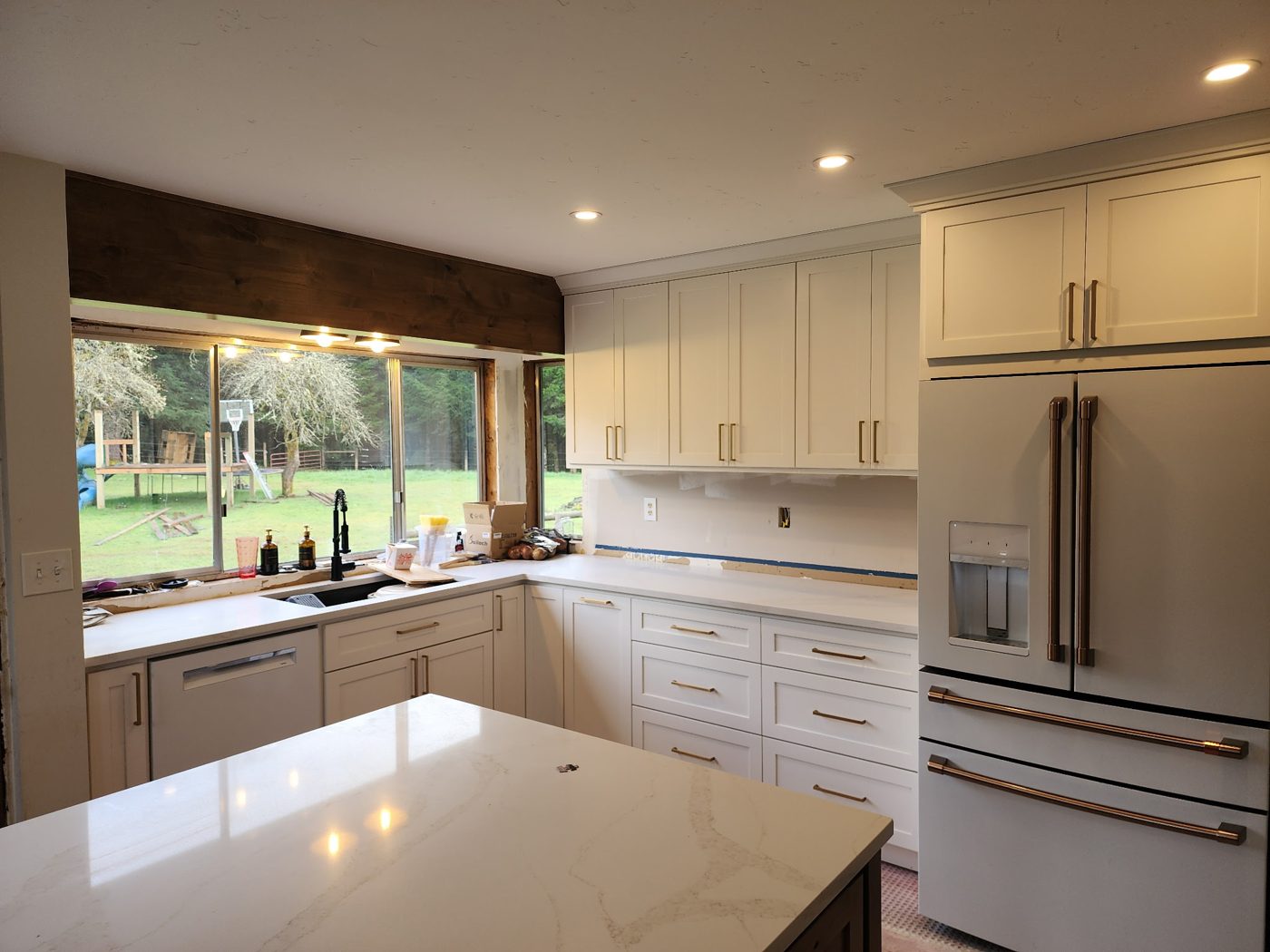 White kitchen with a wood beam window header over the sink